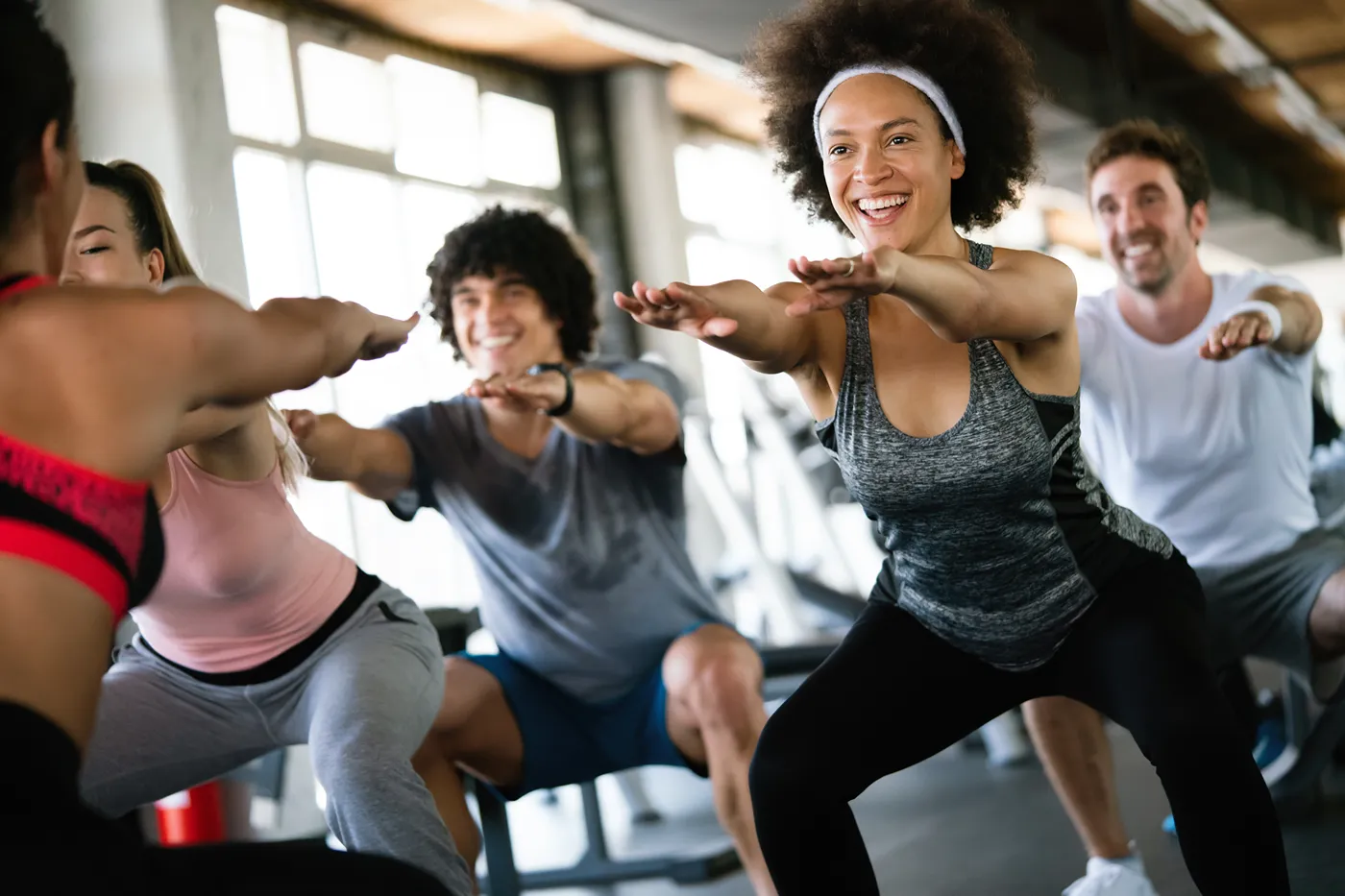 Happy young woman at front onf a group during an exercise class