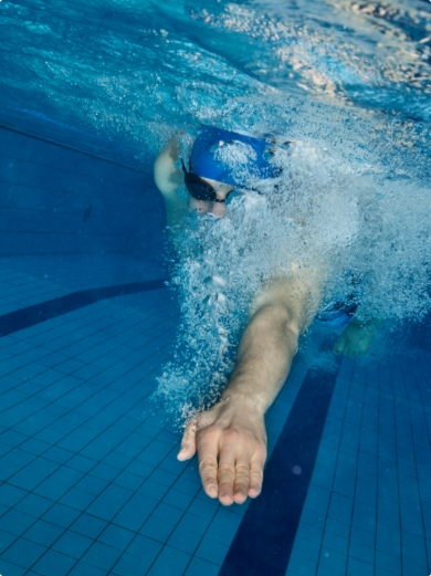 A man swimming in a pool, underwater