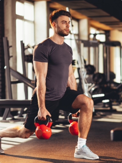 A man doing lunges in a gym whilst holding dumbells