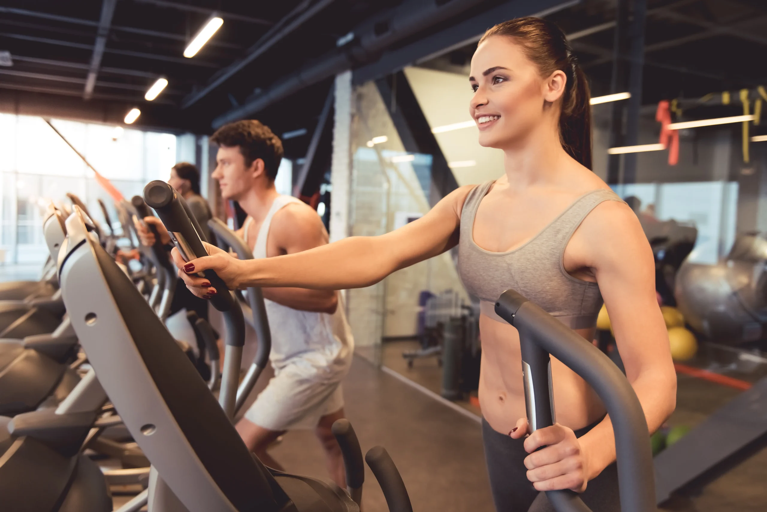 A group of people using cross trainers in a gym