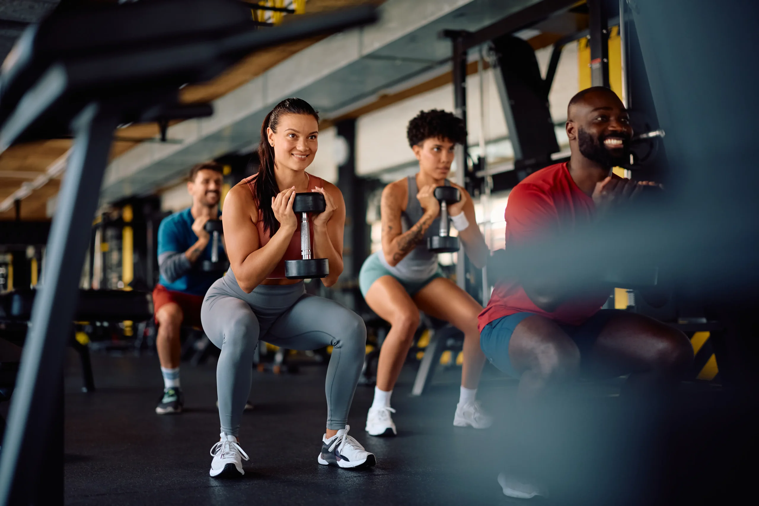 happy athlete and her friends using hand weights