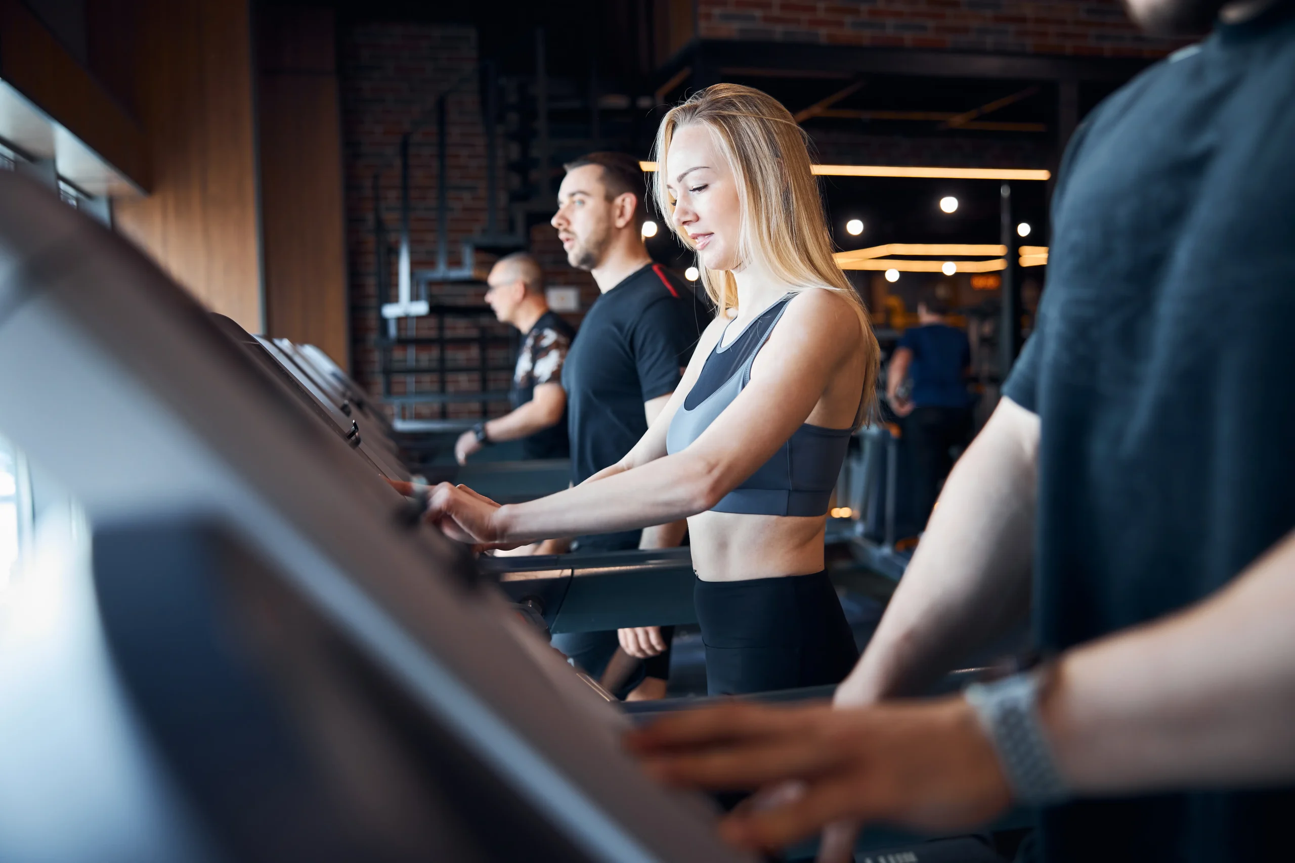 people exercising on treadmills at the gym